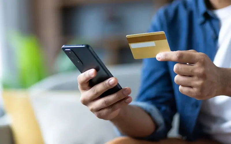 Man holding credit card and phone