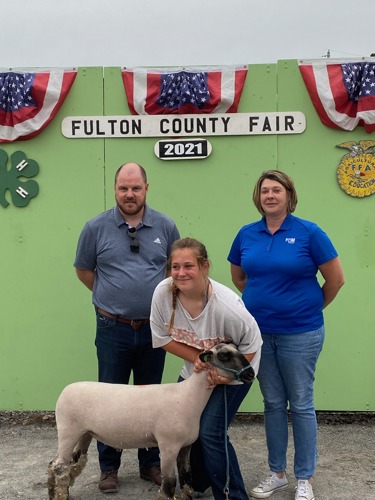 Bank reps standing with Cloe Fletcher and her goat