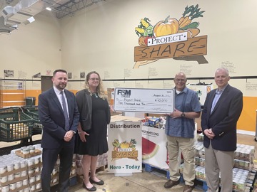 representatives pictured holding large check
