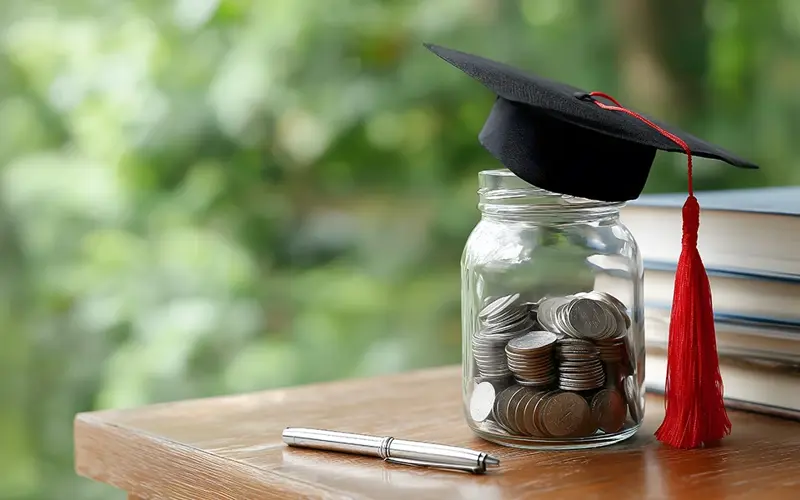 jar fill of coins with a graduation cap