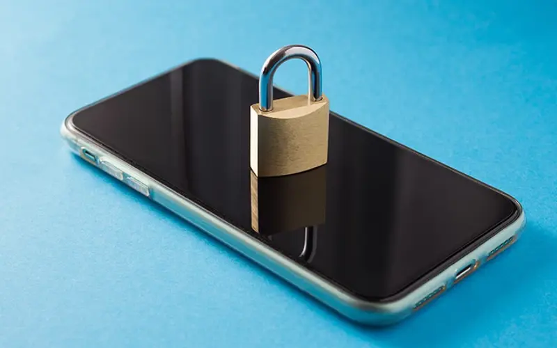 a padlock sitting on top of a mobile phone