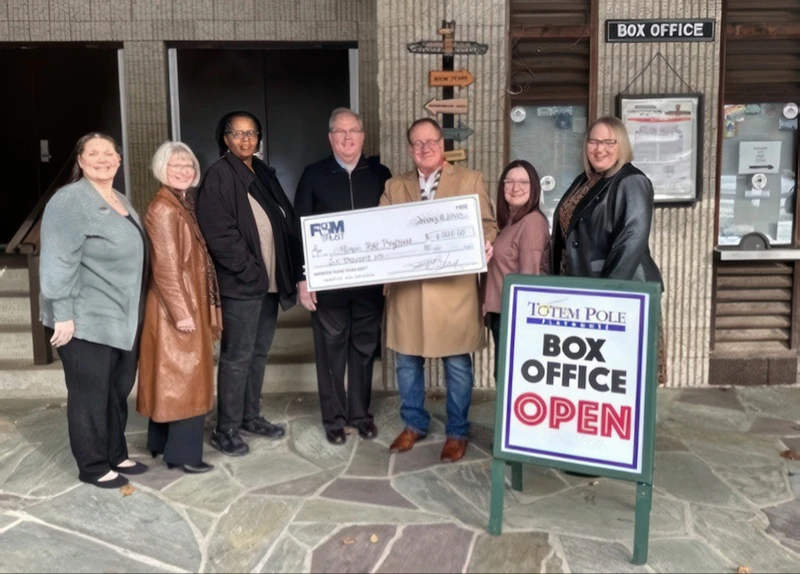 F&M Trust employees present a large check to Totem Pole Playhouse employees outside the playhouse box office.