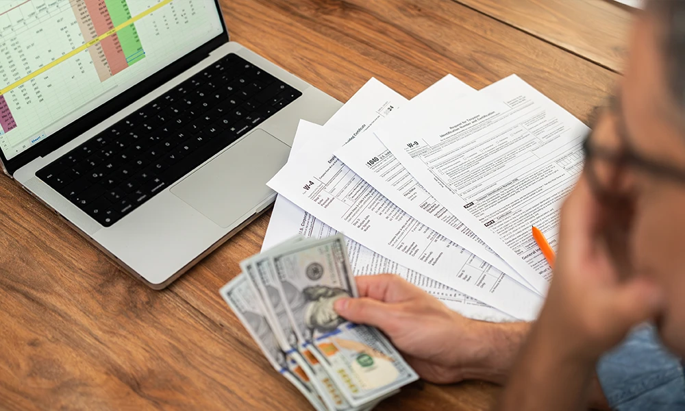 man looking at expenses while filling out tax paperwork