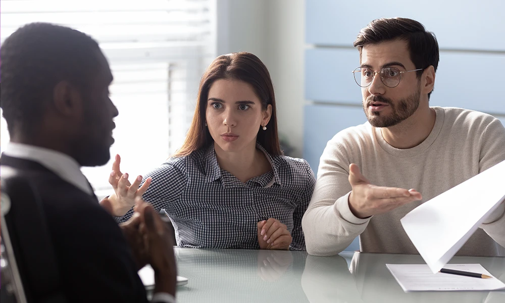 couple talking to advisor looking surprised 