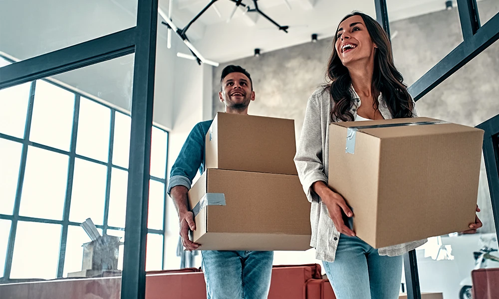 young couple moving boxes into new home