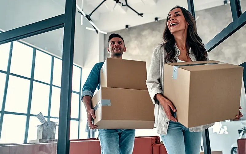 young couple moving boxes into new home