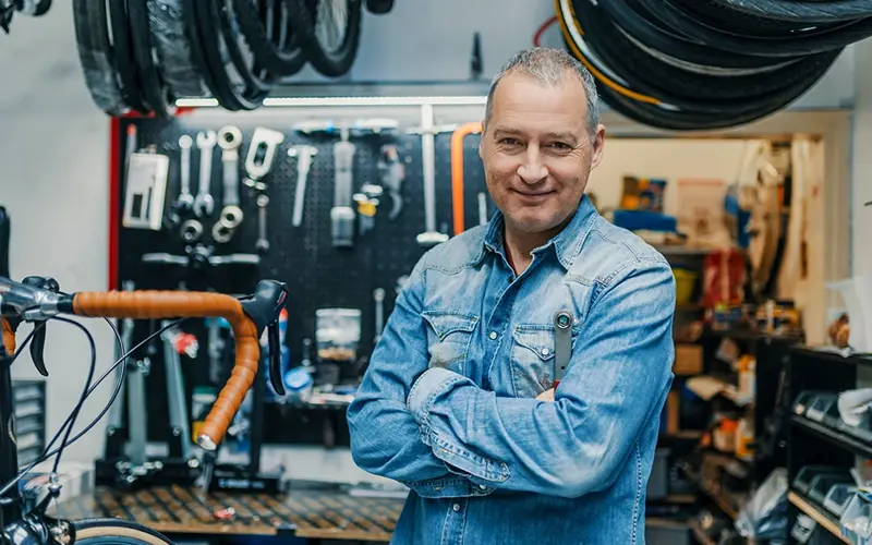 bike mechanic standing in his shop