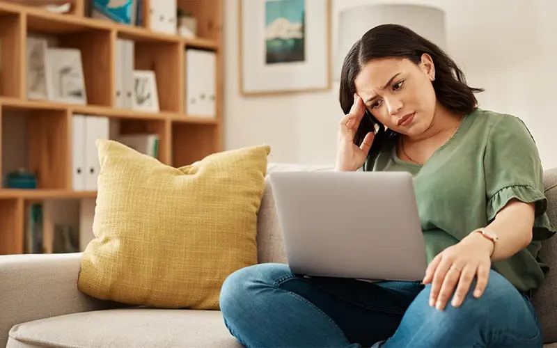 concerned woman looking at her laptop