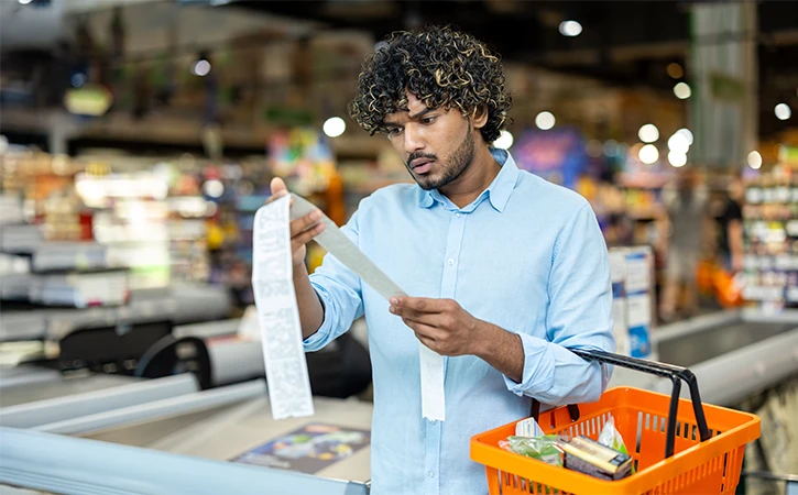 man scrutinizing his grocery receipt