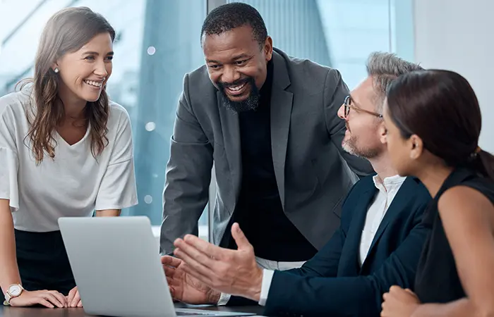 People in business attire looking at laptop