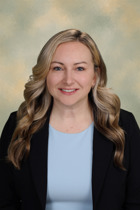 Portrait of Katie Rittel wearing a grey shirt with a black blazer.