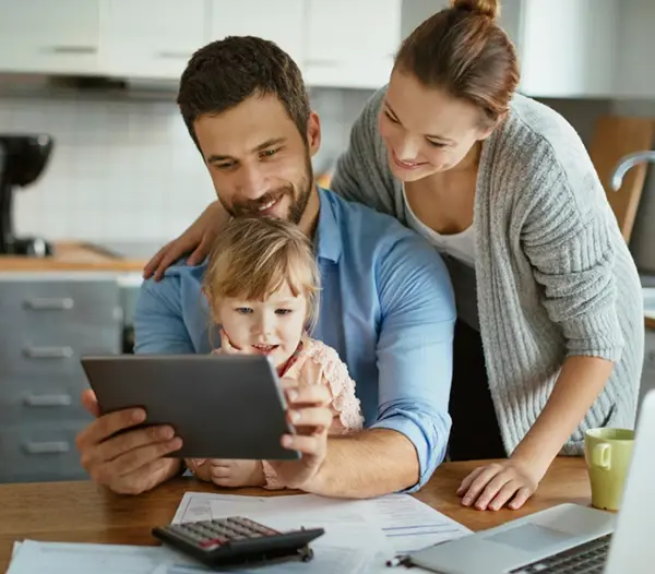 Happy parents using tablet with small daughter at home 