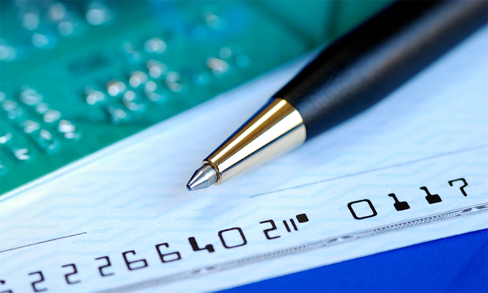 a pen laying on top of a blank check