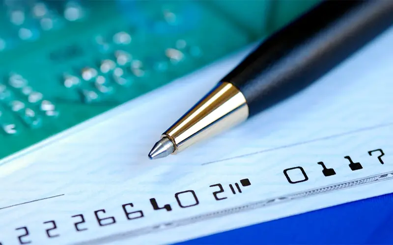 a pen laying on top of a blank check