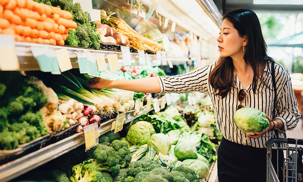 woman buying produce at grocery store