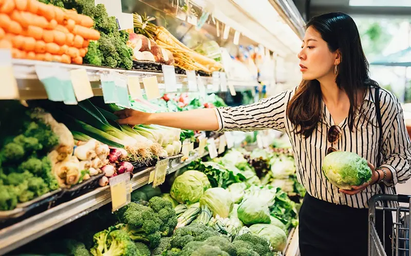 woman buying produce at grocery store