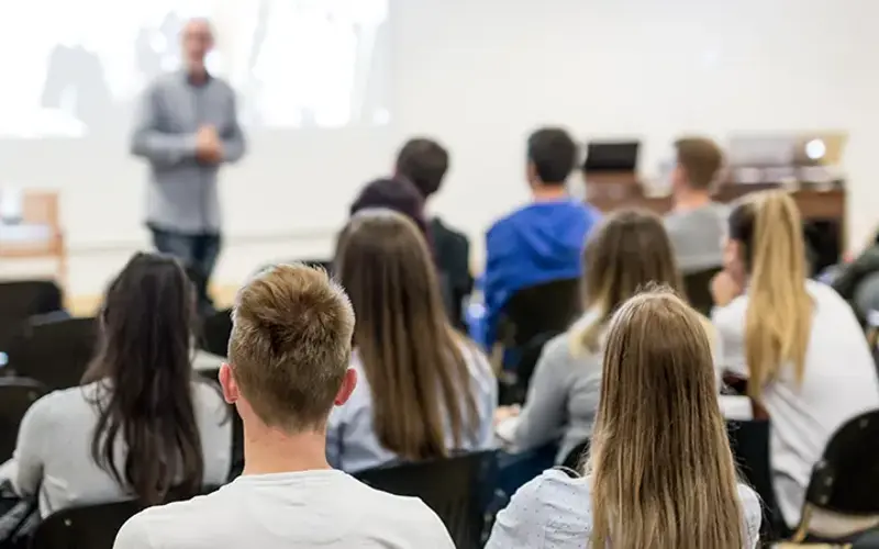 professor teaching college students in a classroom