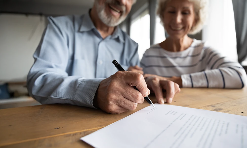 older adult couple signing Power of Attorney paperwork