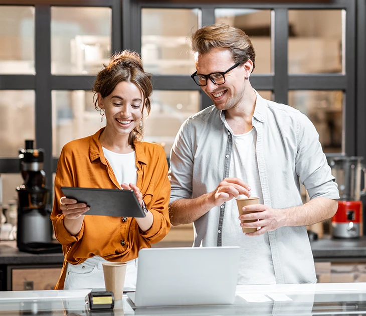 coffee shop owners looking at tablet