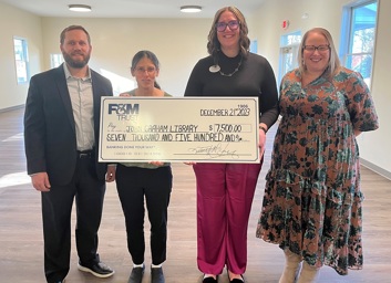 Three F&M Trust employees presenting a large check to a John Graham Library employee.