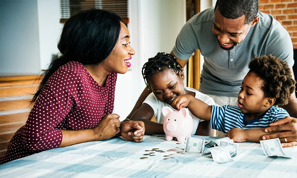parents encouraging their young kids to put money in a piggy bank