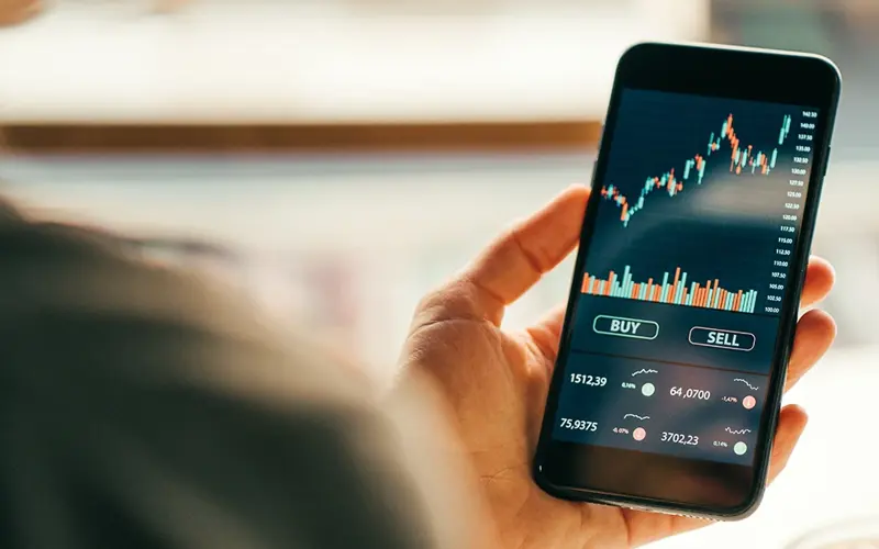 person looking at stocks on mobile phone 