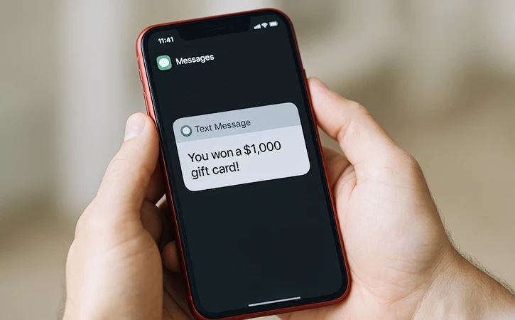 a text message on a smartphone that reads You won a $1,000 gift card! 
