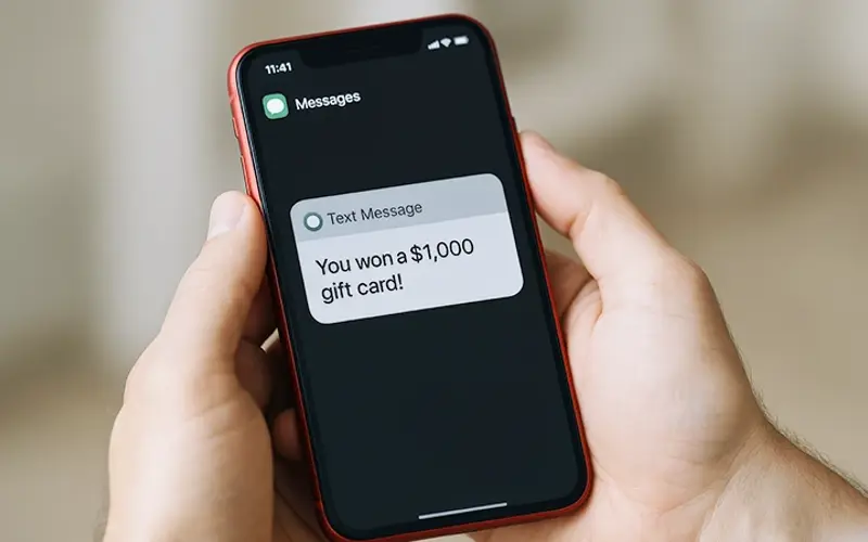 a text message on a smartphone that reads You won a $1,000 gift card! 