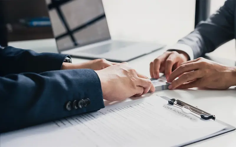 2 men in suits going over a loan agreement