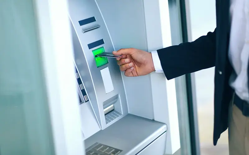 Close-up Of Person Using Credit Card To Withdrawing Money From Atm Machine