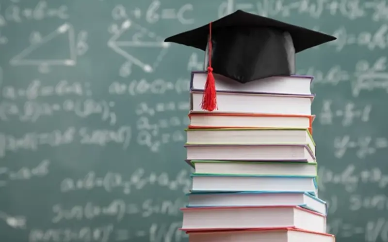 Stack of books with chalk board in the background