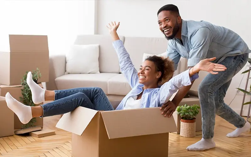 young couple smiling while moving into their home