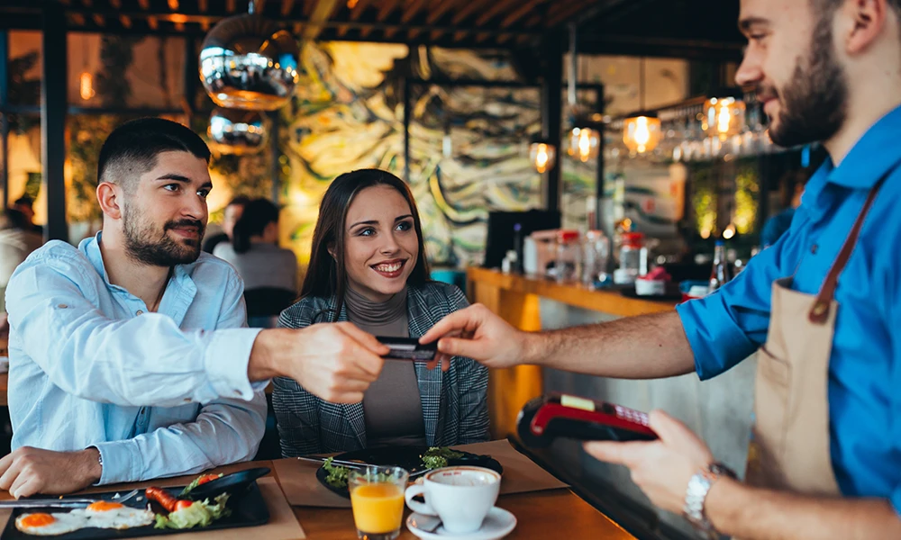 man handing waiter credit card