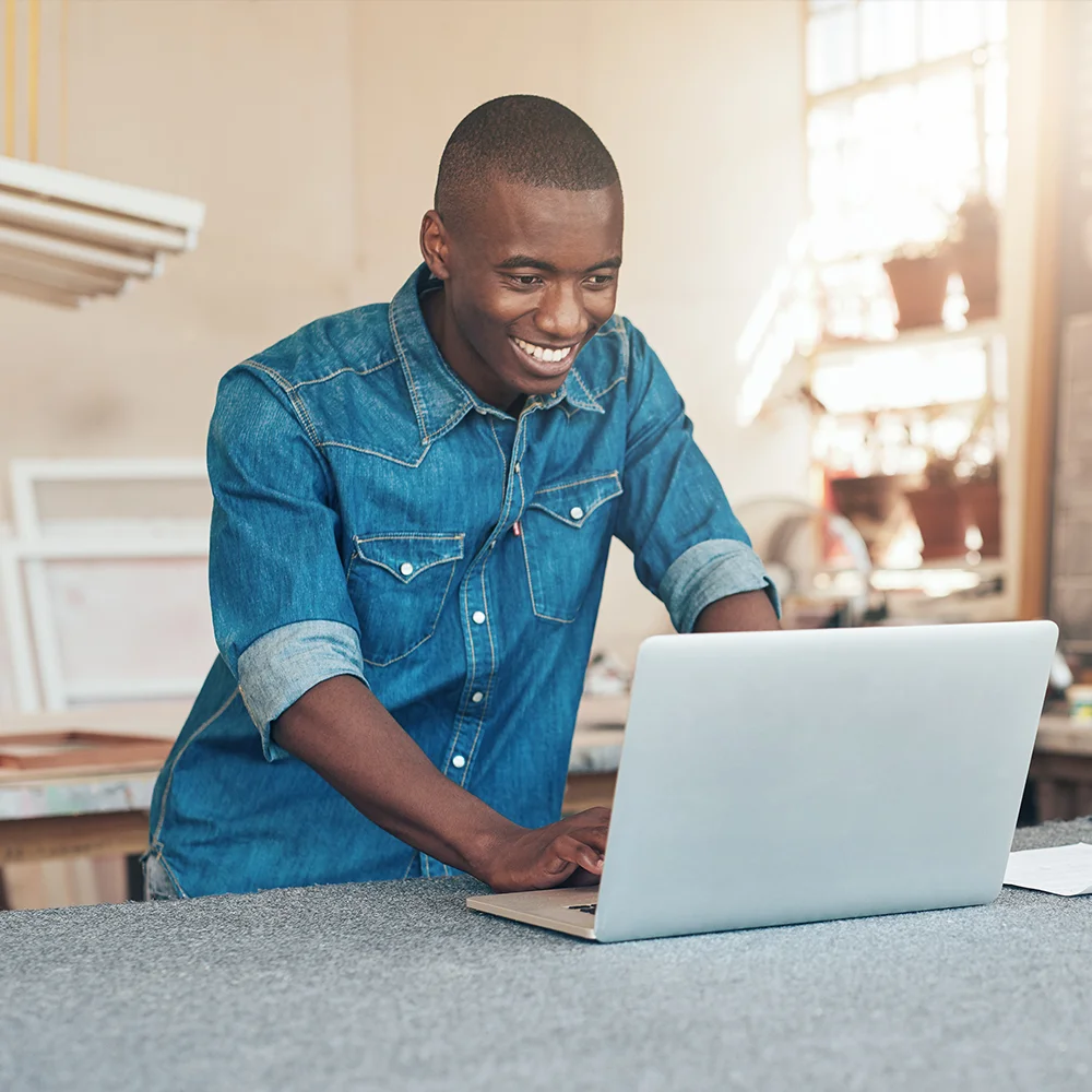 Small business owner using laptop in workshop