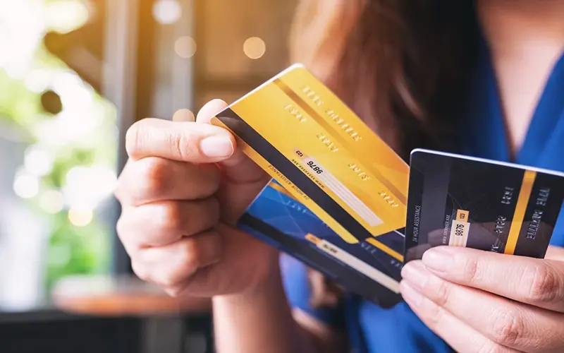 person holding many credit cards